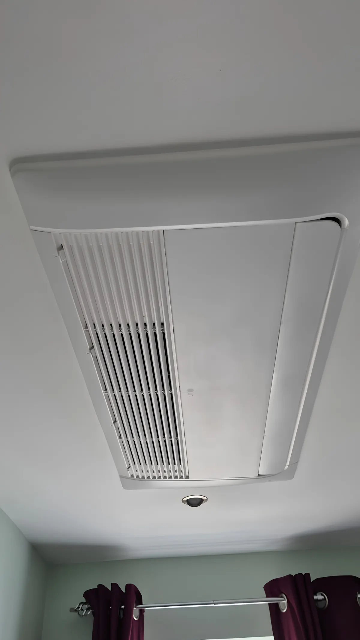 Ceiling cassette air conditioning unit recessed flush into a white ceiling