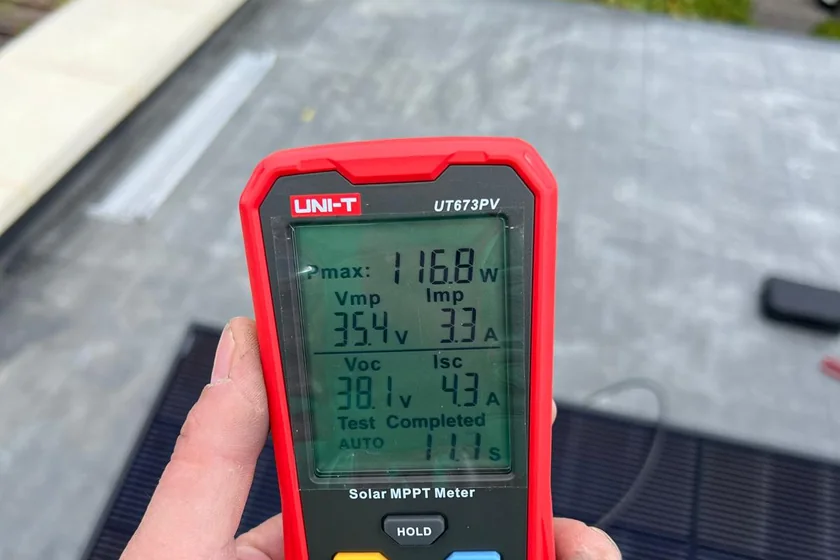 MPPT meter reading 116.8 watts from a panel during commissioning